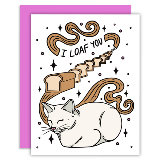 A white cat in a loafing position with a bread swirl above it and the words ‘I loaf you’ on a greeting card. With a purple envelope.