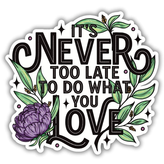 It’s Never Too Late To Do What You Love Vinyl Sticker. Purple flower and green leaves and decoration with text that says it’s never too late to do what you love on a vinyl sticker.
