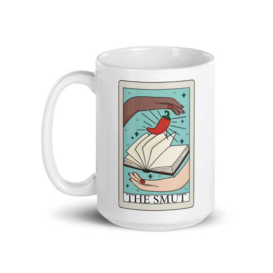 Two hands around a book with a chili pepper on a blue background on a tarot card that's printed on a white ceramic mug.