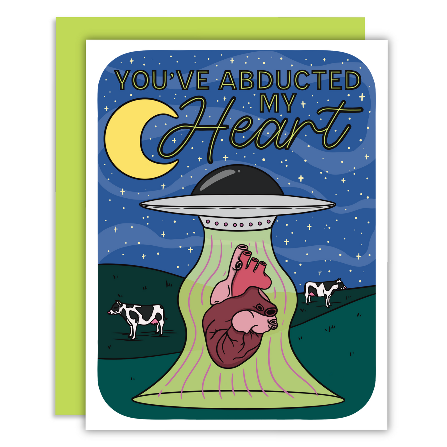 Design of a greeting card featuring a gray UFO beaming up a red heart, with cows grazing in the background under a starry night sky. Decorative text on the card reads 'You’ve abducted my heart,' blending a romantic and whimsical extraterrestrial theme.