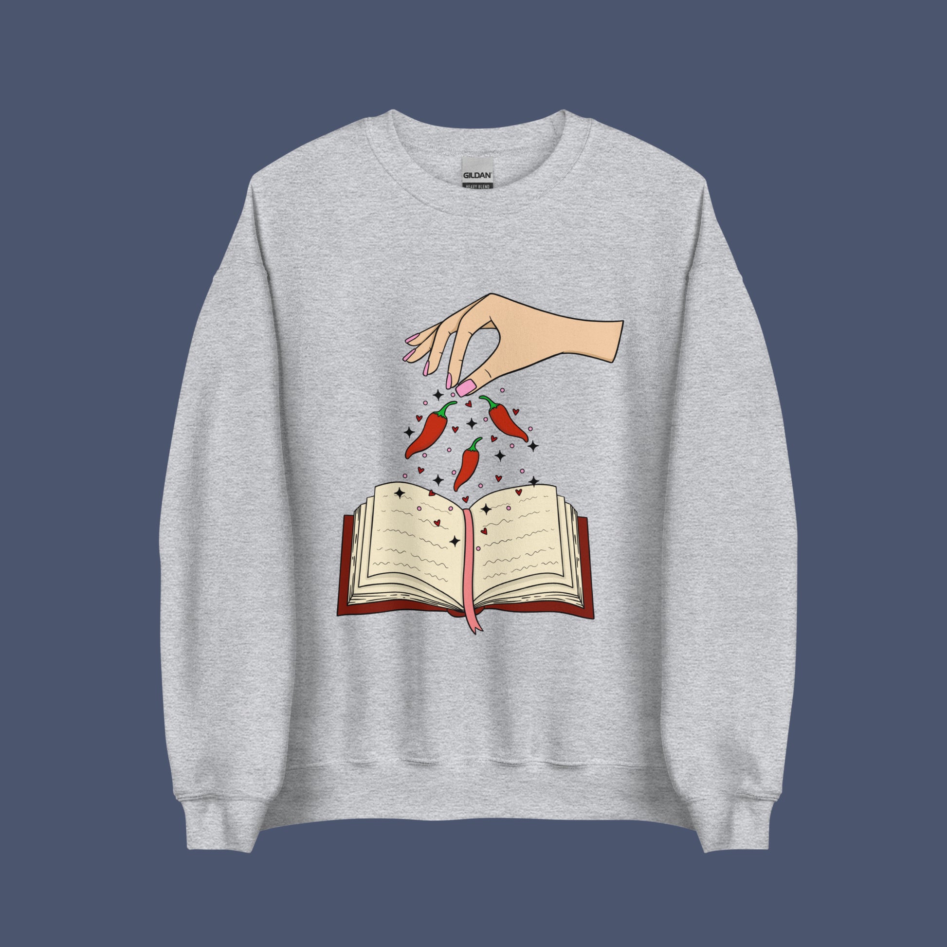 Spicy Books Fair Crew Neck Sweatshirt, Hand with chills sprinkling over book. Keywords: romance sweatshirt, smut reader, book lover hoodie, enemies to lovers, dark romance, smutty, spicy books, bookish sweatshirt, book gift under 50, fantasy romance