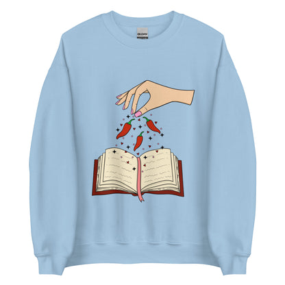 Spicy Books Fair Crew Neck Sweatshirt, Hand with chills sprinkling over book. Keywords: romance sweatshirt, smut reader, book lover hoodie, enemies to lovers, dark romance, smutty, spicy books, bookish sweatshirt, book gift under 50, fantasy romance